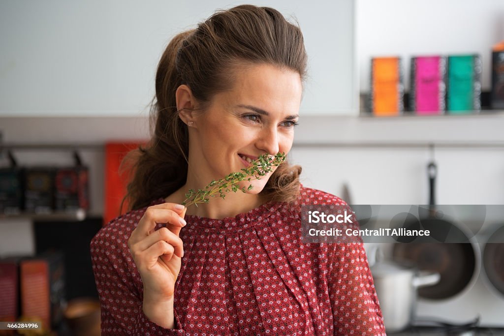 portrait of happy young housewife with fresh thymus Portrait of happy young housewife with fresh thymus Thyme Stock Photo