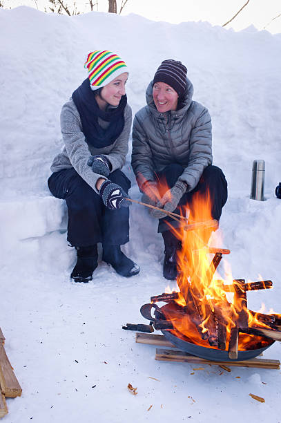 istock Mother and Daughter Cook Hot Dogs Over a Fire Pit. 466285254
