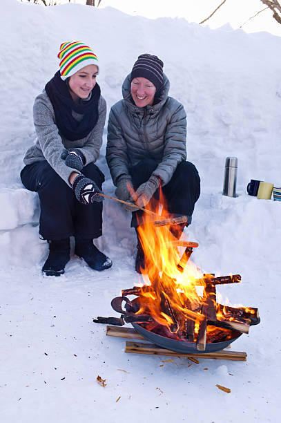 istock Mother and Daughter Cook Hot Dogs Over a Fire Pit. 466285322