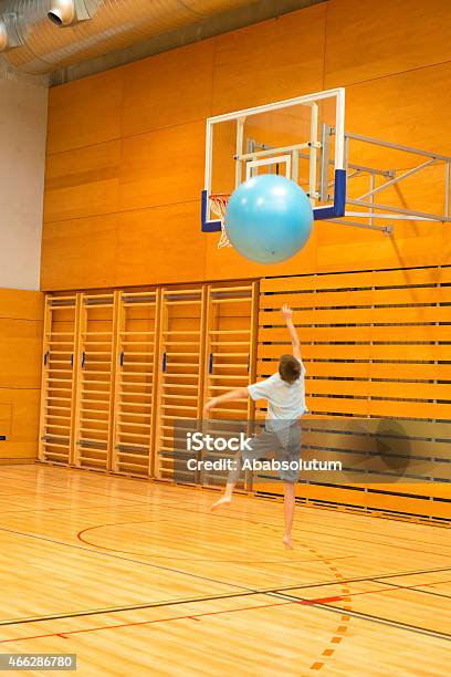 Boy With Big Azul Pelota De Ejercicio De Jugar Al Básquetbol El Gimnasio Escolar Foto de stock y más banco de imágenes de Raro