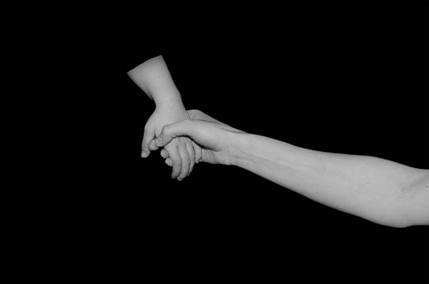istock mother and child holding hands in black and white 466286940
