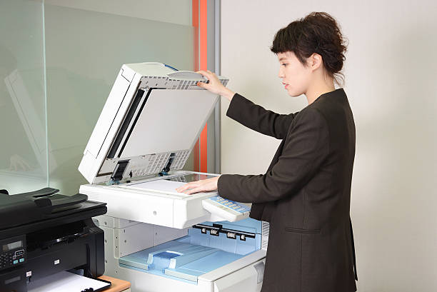 istock Young Asian business woman using a copy machine. 466287200