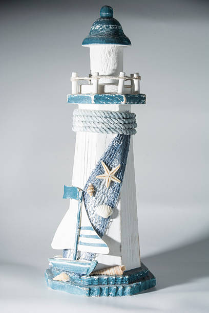 istock White and blue wooden light house with boat 466289649