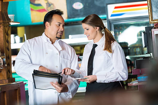 istock Chef holding menu, training new waitress in Tex-Mex restaurant 466290044