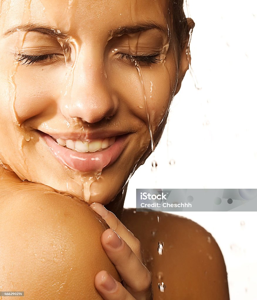 woman face with water drop  Close-up of beautiful wet woman face with water drop. On white background 2015 Stock Photo