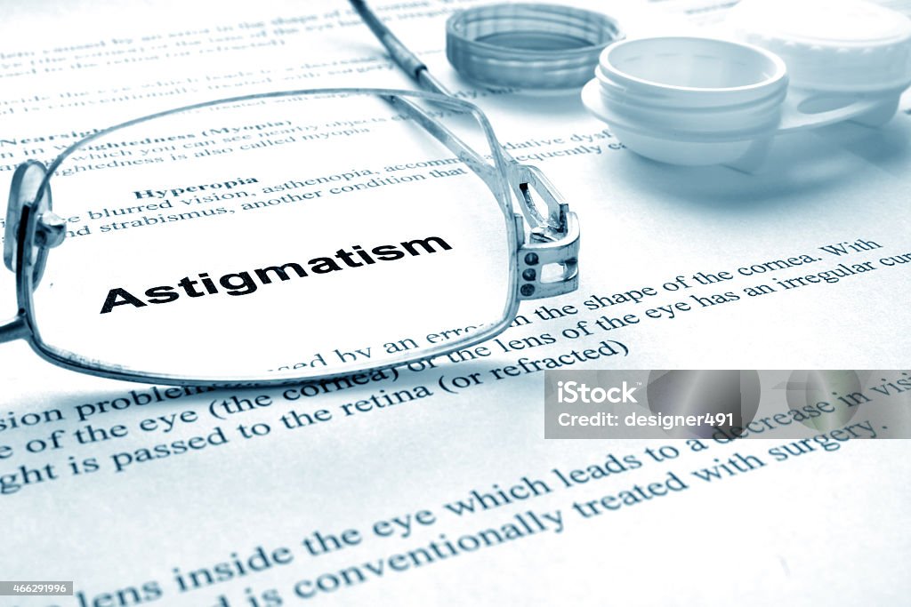 Paper with word astigmatism. Paper with word astigmatism, glases and container for lenses. Eye disorders.  Astigmatism Stock Photo