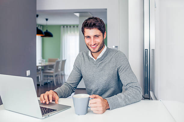 istock Handsome young smiling businessman working from home 466296184