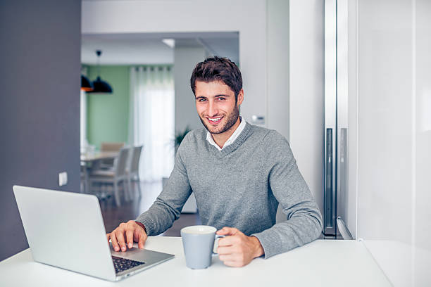 istock Young smiling businessman working from home in a grey theme 466296208