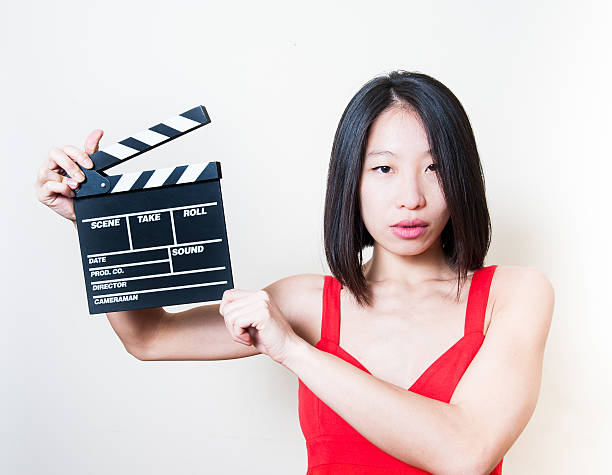 istock Young beautiful asian woman holding clapperboard 466301198