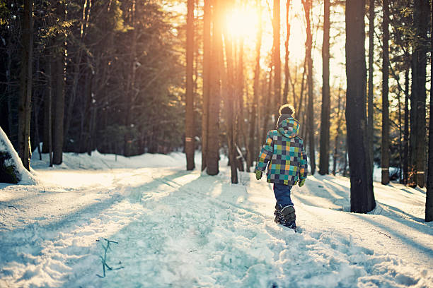 ragazzino camminare nella foresta invernale - art coat full length foto e immagini stock