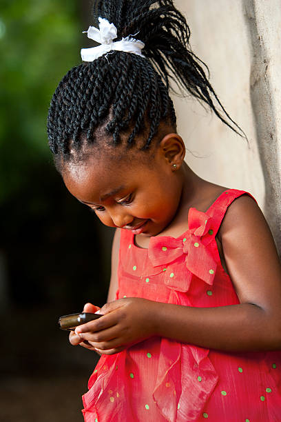 istock Pigtailed african girl playing with smart phone. 466305599