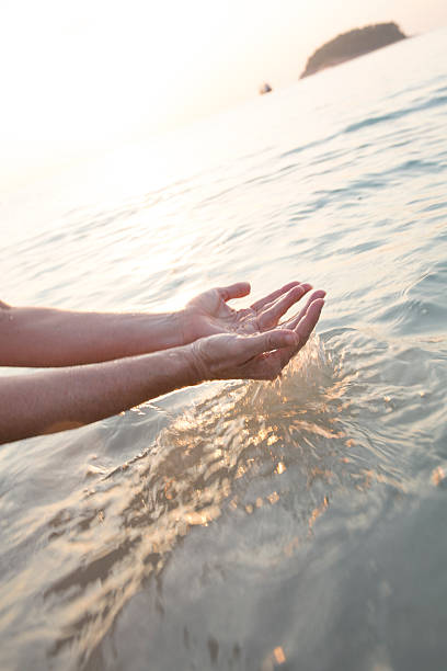 istock Woman's hands scoop water from open sea 466307382