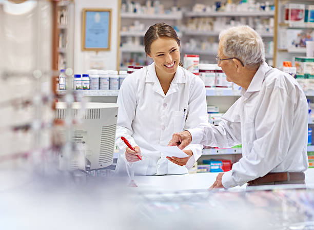 Providing clients with all the information they need Shot of a young pharmacist helping an elderly customer at the prescription counter. The commercial product(s) or designs displayed in this image represent simulations of a real product, and are changed or altered enough so that they are free of any copyright infringements. Our team of retouching and design specialists custom designed these elements for each photo shoot http://195.154.178.81/DATA/i_collage/pi/shoots/785200.jpg checkout photos stock pictures, royalty-free photos & images