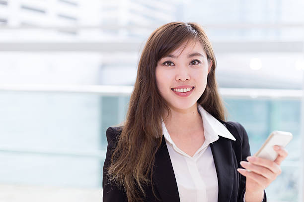 istock asian successful businesswoman using smart phone at office corridor 466312060