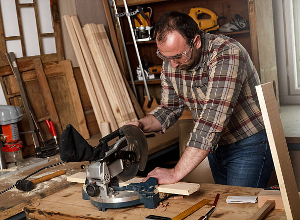 istock Carpenter cutting wooden plank with circular saw. 466314504