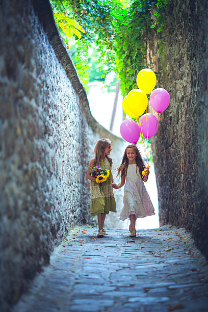 Two pretty young girls are enjoying being together outside on the street.