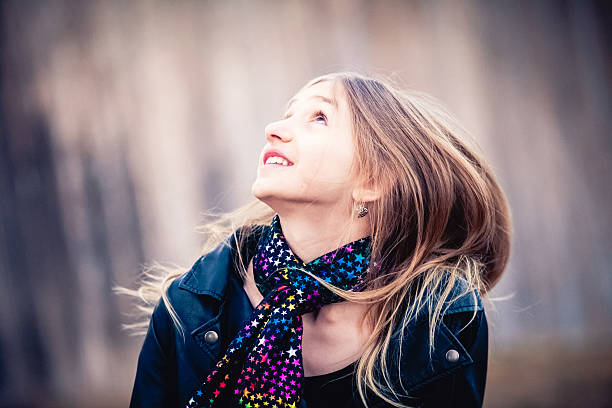 istock Long haired blonde tween girl looking up with smile 466314640