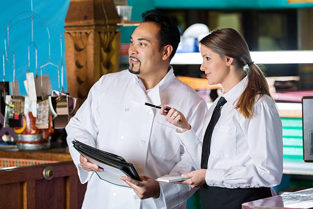 istock Chef and waitress talking near commercial kitchen in restaurant 466315032