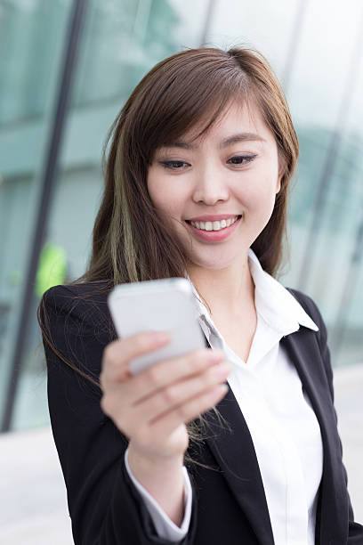 istock asian successful businesswoman using smart phone at office corridor 466318520