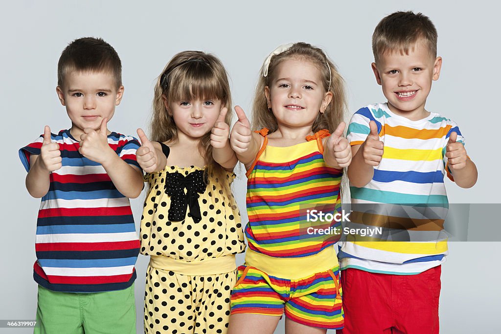Group of children Four children are standing together on the grey background 4-5 Years Stock Photo