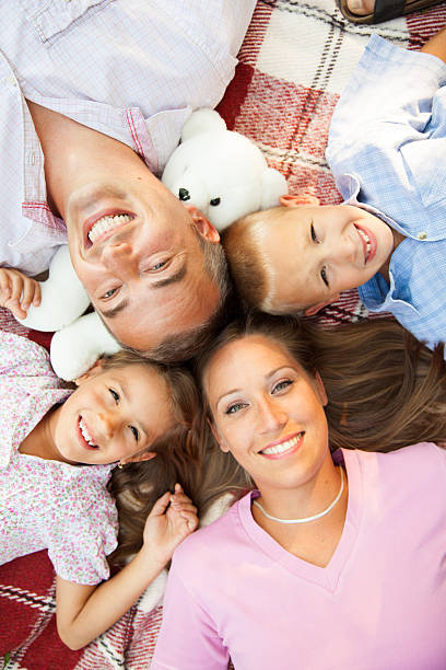 istock Delightful family smiling at camera in the park 466320116