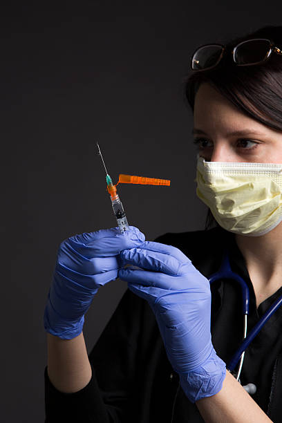 op-mundschutz trägt medizinische krankenschwester mit gesundheitswesen medizin impfstoff spritze - syringe medical injection surgical needle surgical mask stock-fotos und bilder