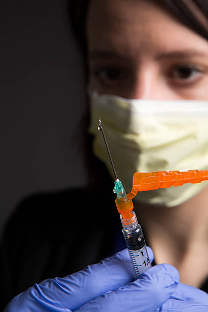 máscara quirúrgica usando enfermera médico con la jeringa vacuna asistencia sanitaria y medicina - syringe medical injection surgical needle surgical mask fotografías e imágenes de stock