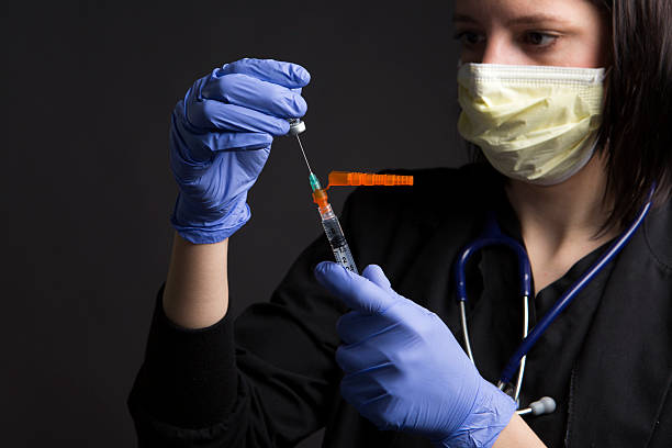 op-mundschutz trägt medizinische krankenschwester mit gesundheitswesen medizin impfstoff spritze - syringe medical injection surgical needle surgical mask stock-fotos und bilder