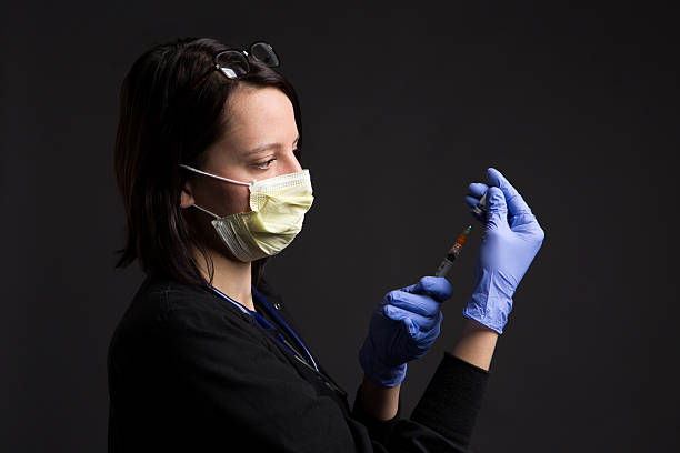 máscara quirúrgica usando enfermera médico con la jeringa vacuna asistencia sanitaria y medicina - syringe medical injection surgical needle surgical mask fotografías e imágenes de stock