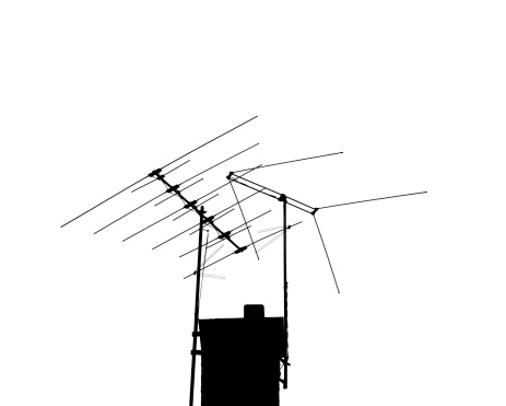 Two TV antennas backlit against a white sky. Very high Contrast.