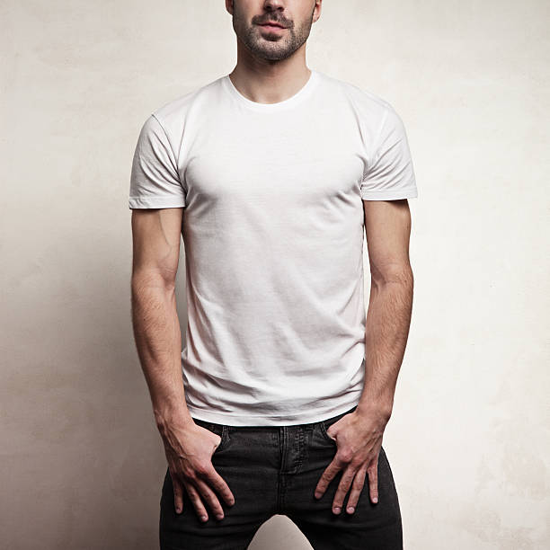 White blank t-shirt on a young man isolated, front, concrete wall background