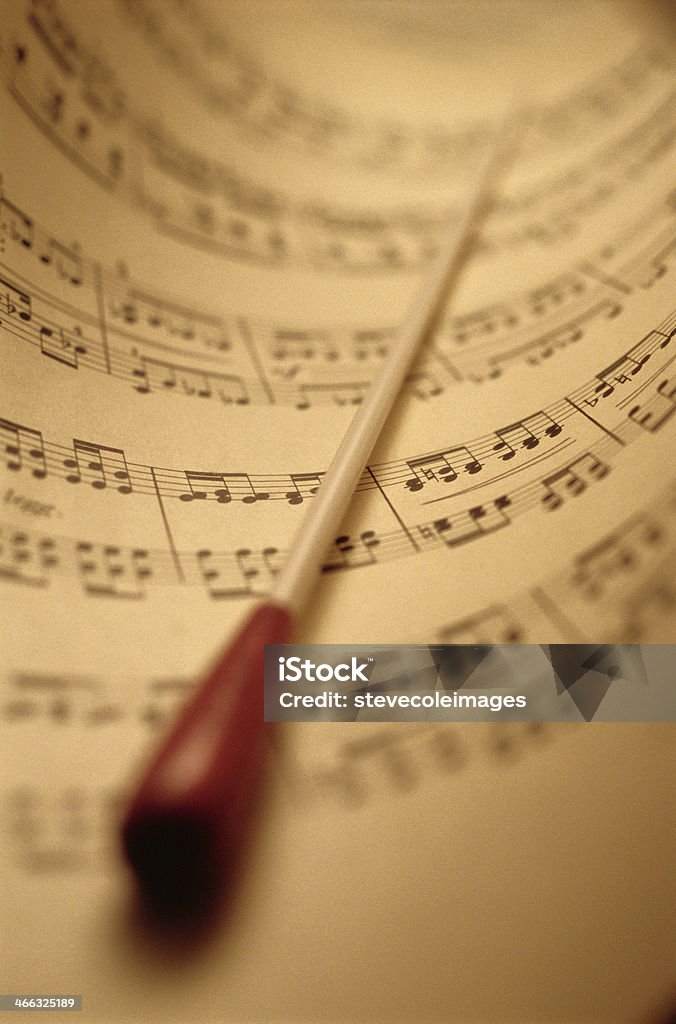 Sheet Music And Baton Baton laying down on top of sheet music. Conductor's Baton Stock Photo