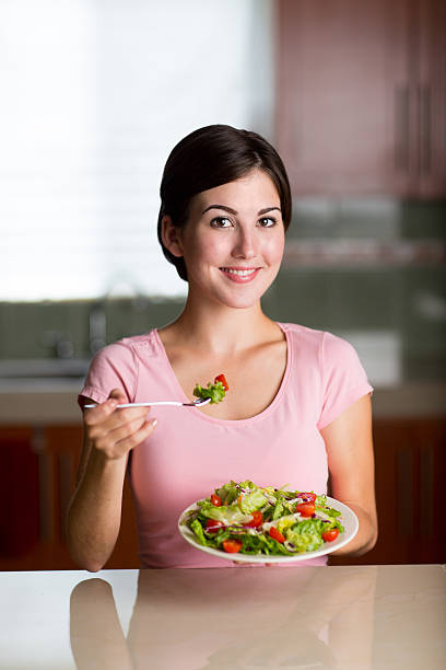 istock Smiling woman eating vegetable salad 466327166