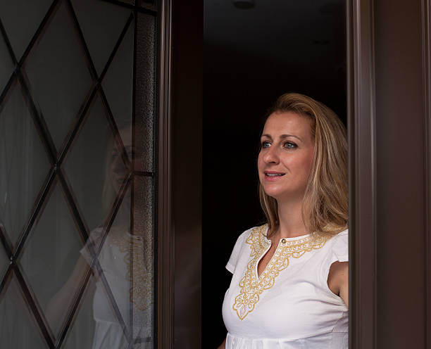 istock Young woman is opening front door 466328064