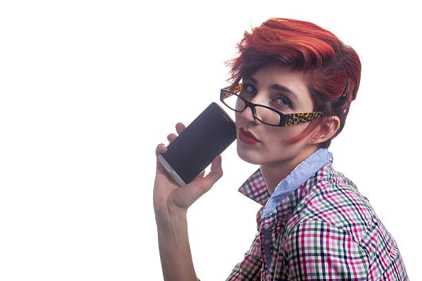 Fashionable modern red haired business woman holds smartphone stock photo