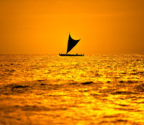 Outrigger Canoe An outrigger canoe sailing across Hawaiian waters outrigger stock pictures, royalty-free photos & images