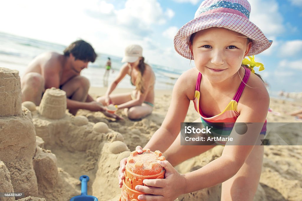 Building a sand castle Young happy family building a sandcastle.  Sandcastle - Structure Stock Photo