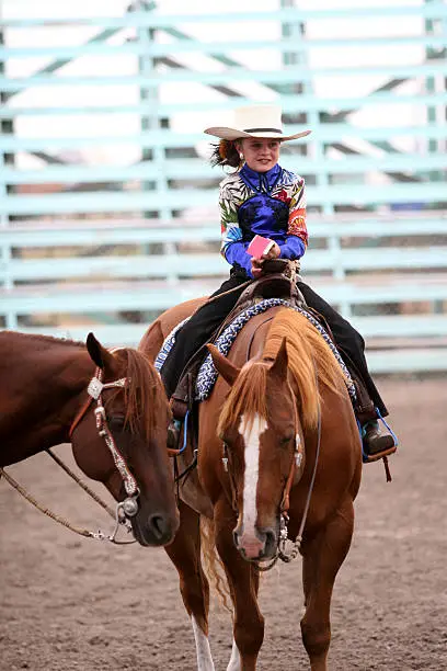 cowgirl riding a horse in an arena during fair