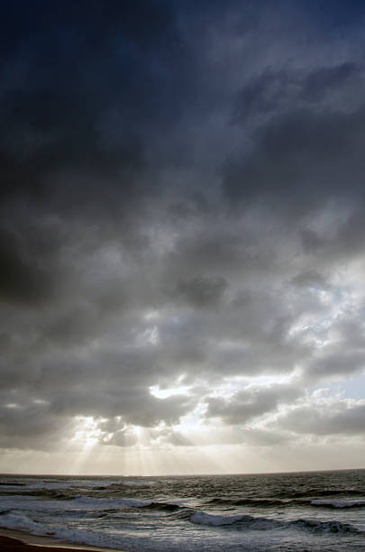 landscape, rough sea, cloudy sky by storm, burst of light