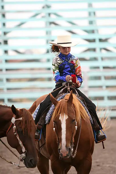 cowgirl riding a horse in an arena during fair