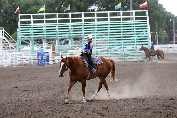 cowgirl riding a horse in an arena during fair