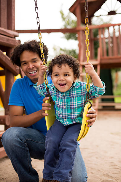 istock Happy father and son playing on swing 466333532