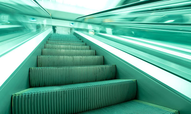 istock angle view to modern green steps of moving business escalator 466333577