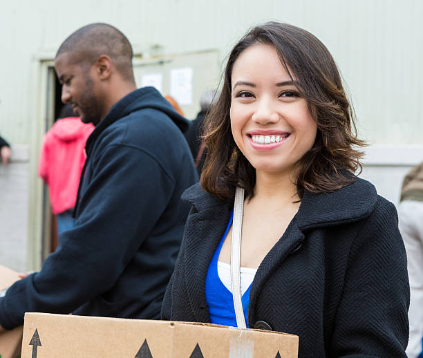 giovane donna con scatola di donazioni generi alimentari dall'esterno cibo bank - homelessness food in a row people foto e immagini stock