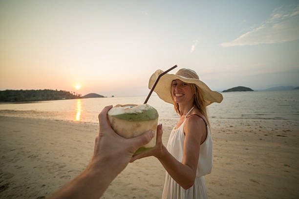 istock Cheerful couple on tropical vacation sharing a coconut 466333864