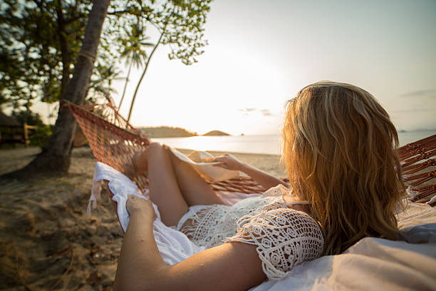 istock Woman on hammock looking at sunset 466333910