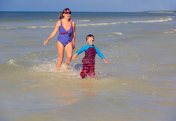 istock mother and son running at the sea 466334128
