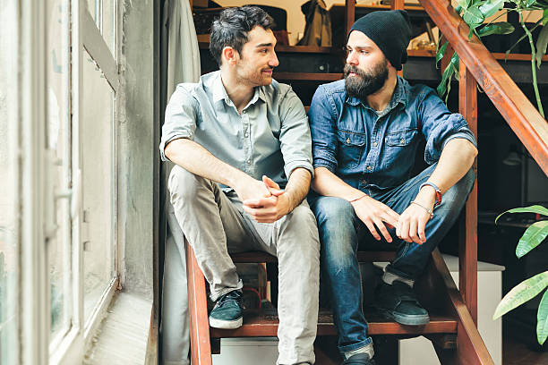 istock Two friends looking each other sitting on stairs 466334734