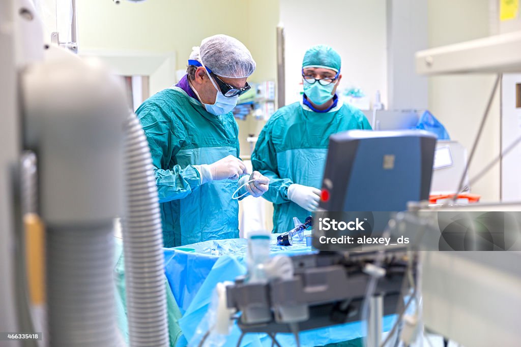 Two doctors in scrubs working in the operating room Doctors working in operating room 2015 Stock Photo