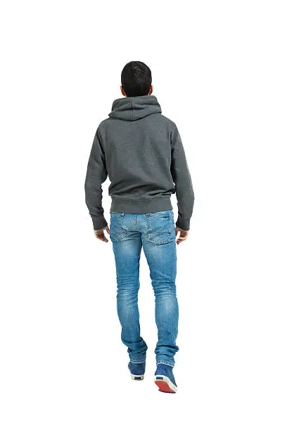 Photo of Young man walking away wearing jeans and a sweatshirt